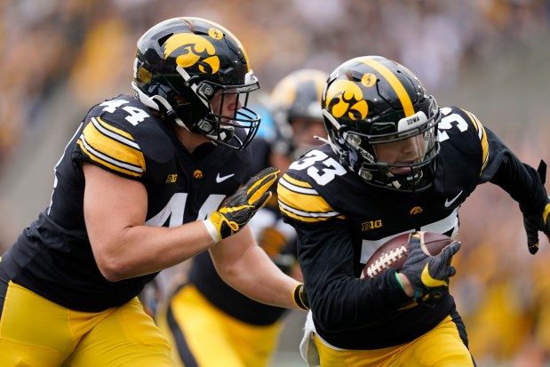 Iowa defensive back Riley Moss (33) returns an interception 30-yards for a touchdown during the first half of an NCAA college football game against Indiana, Saturday, Sept. 4, 2021, in Iowa City, Iowa. (AP Photo/Charlie Neibergall)