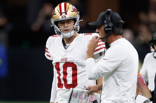 San Francisco 49ers quarterback Mac Jones (10) talks with head...