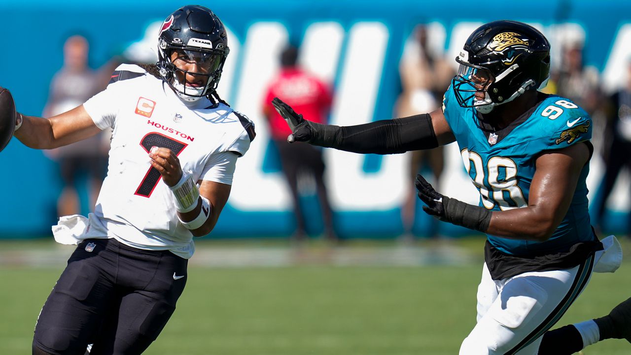 Houston Texans quarterback CJ. Stroud (7) runs the ball as Jacksonville Jaguars defensive end Dawuane Smoot (98) defends during the second half of an NFL football game Sunday, Sept. 21, 2025, in Jacksonville, Fla. (AP Photo/John Raoux)
