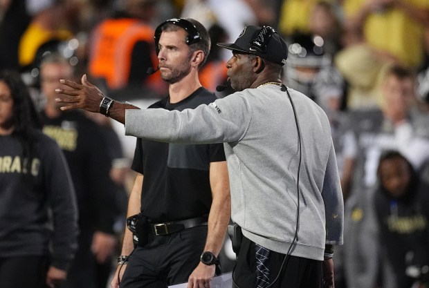 Colorado head coach Deion Sanders, front, confers with defensive coordinator Robert Livingston late in the second half of an NCAA college football game against Brigham Young Saturday, Sept. 27, 2025, in Boulder, Colo. (AP Photo/David Zalubowski)