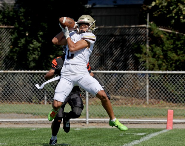Haverhill's George Papanikolaou pulls in a TD pass in front of Beverly's Xavier Auk during a non-league football game in Beverly. (Staff Photo By Stuart Cahill/Boston Herald)