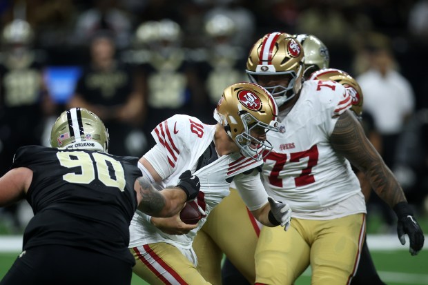 Mac Jones #10 of the San Francisco 49ers is wrapped...