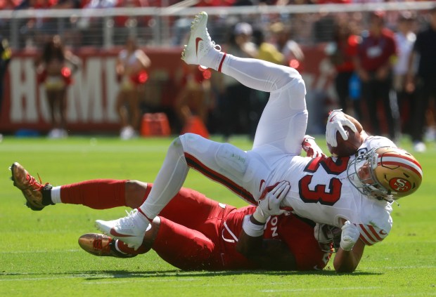 San Francisco 49ers' Christian McCaffrey (23) is tackled by Arizona Cardinals' Mack Wilson Sr. (2) in the second quarter at Levi's Stadium in Santa Clara, Calif., on Sunday, Sept. 21, 2025. (Nhat V. Meyer/Bay Area News Group)