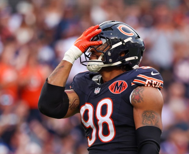 Montez Sweat (98) sputs his hand over his face after...