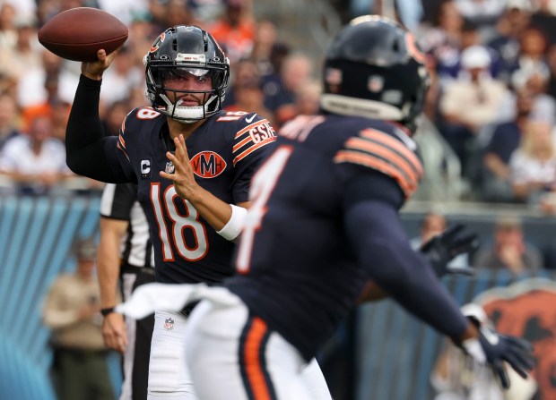 Chicago Bears quarterback Caleb Williams passes to running back D'Andre...