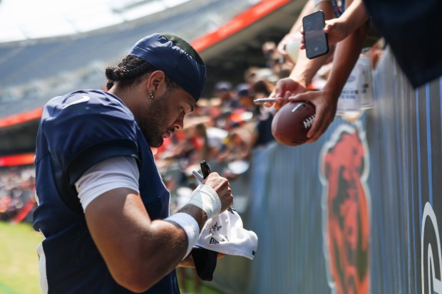 Chicago Bears wide receiver Rome Odunze (15) signs autographs for...