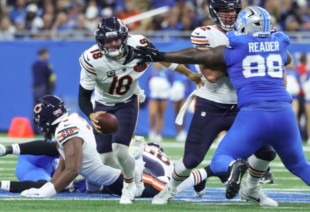 Bears quarterback Caleb Williams is grabbed by Lions defensive tackle...