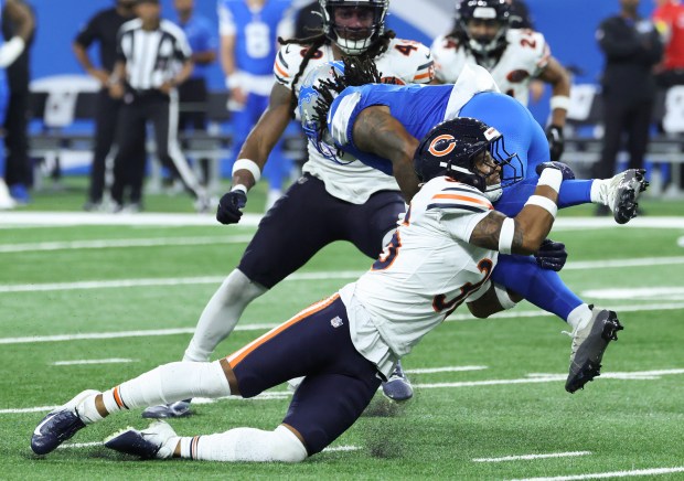 Bears safety Jonathan Owens tackles Lions running back Jahmyr Gibbs...