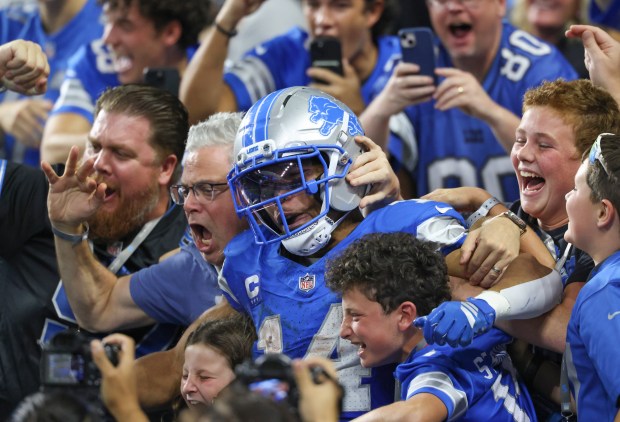 Lions wide receiver Amon-Ra St. Brown celebrates with fans after...