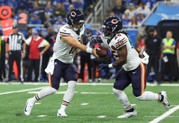 Bears quarterback Tyson Bagent hands off to running back Kyle...