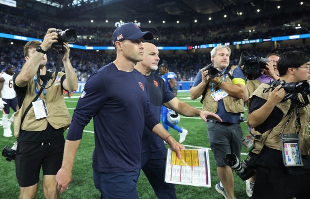 Bears coach Ben Johnson walks to greet Lions coach Dan...