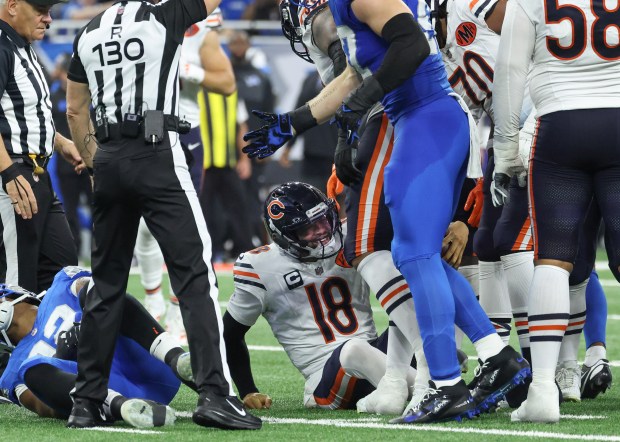 Bears quarterback Caleb Williams grimaces after getting sacked in the...