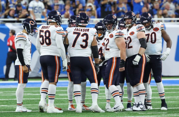 Bears quarterback Caleb Williams, left, waits with the offense to...