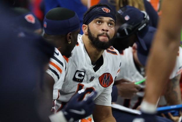 Bears quarterback Caleb Williams sits on the bench in the...
