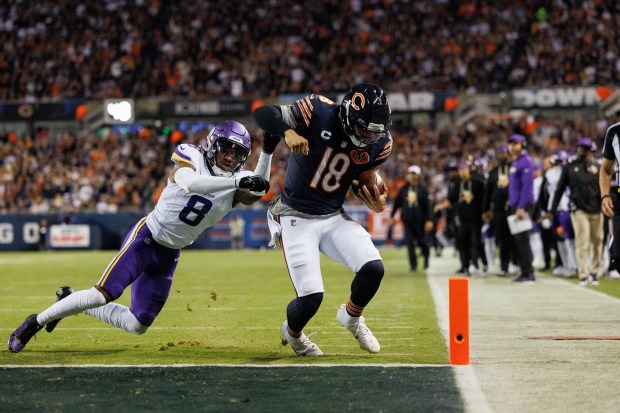 Bears quarterback Caleb Williams scores a touchdown past Vikings cornerback...
