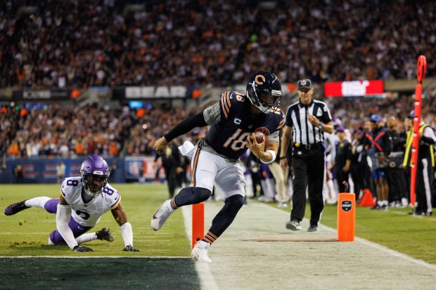 Chicago Bears quarterback Caleb Williams (18) scores a touchdown past...