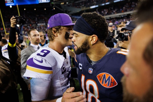 Vikings quarterback J.J. McCarthy (9) hugs Bears quarterback Caleb Williams...