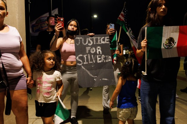 People gather outside the Village of Franklin Park police station,...