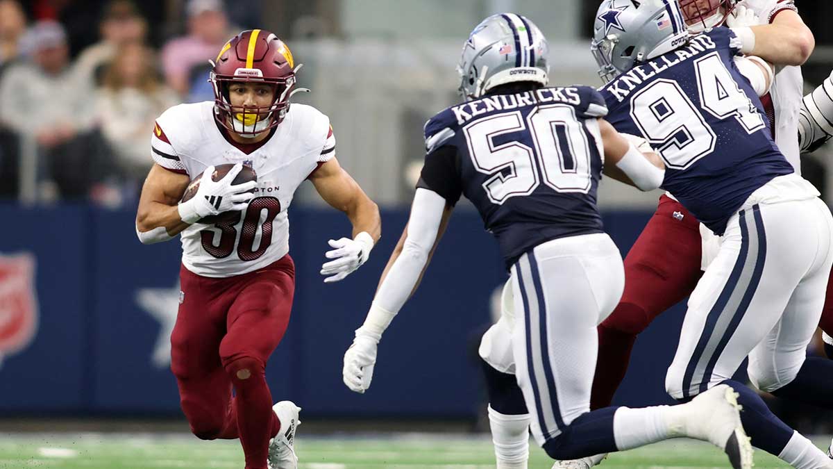 Washington Commanders running back Austin Ekeler (30) runs the ball against the Dallas Cowboys during the second quarter at AT&T Stadium.
