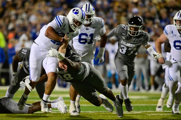 Colorado defensive tackle Alexander McPherson, right, tackles BYU quarterback Bear Bachmeier, left, at Folsom Field in Boulder on Saturday, Sept. 27, 2025. (Matthew Jonas/Staff Photographer)