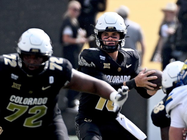 Colorado quarterback Ryan Staub, center, steps back to pass against...