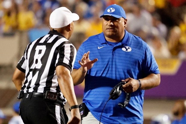 BYU head coach Kalani Sitake, right, speaks with an official, left, during the first half of an NCAA college football game against East Carolina in Greenville, N.C., Saturday, Sept. 20, 2025. (AP Photo/Karl DeBlaker)