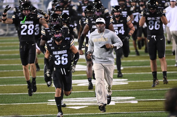 University of Colorado Buffaloes head football coach, Deion Sanders, runs...