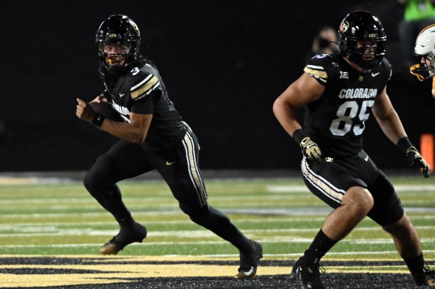 University of Colorado Buffaloes quarterback Colorado quarterback Kaidon Salter rolls...