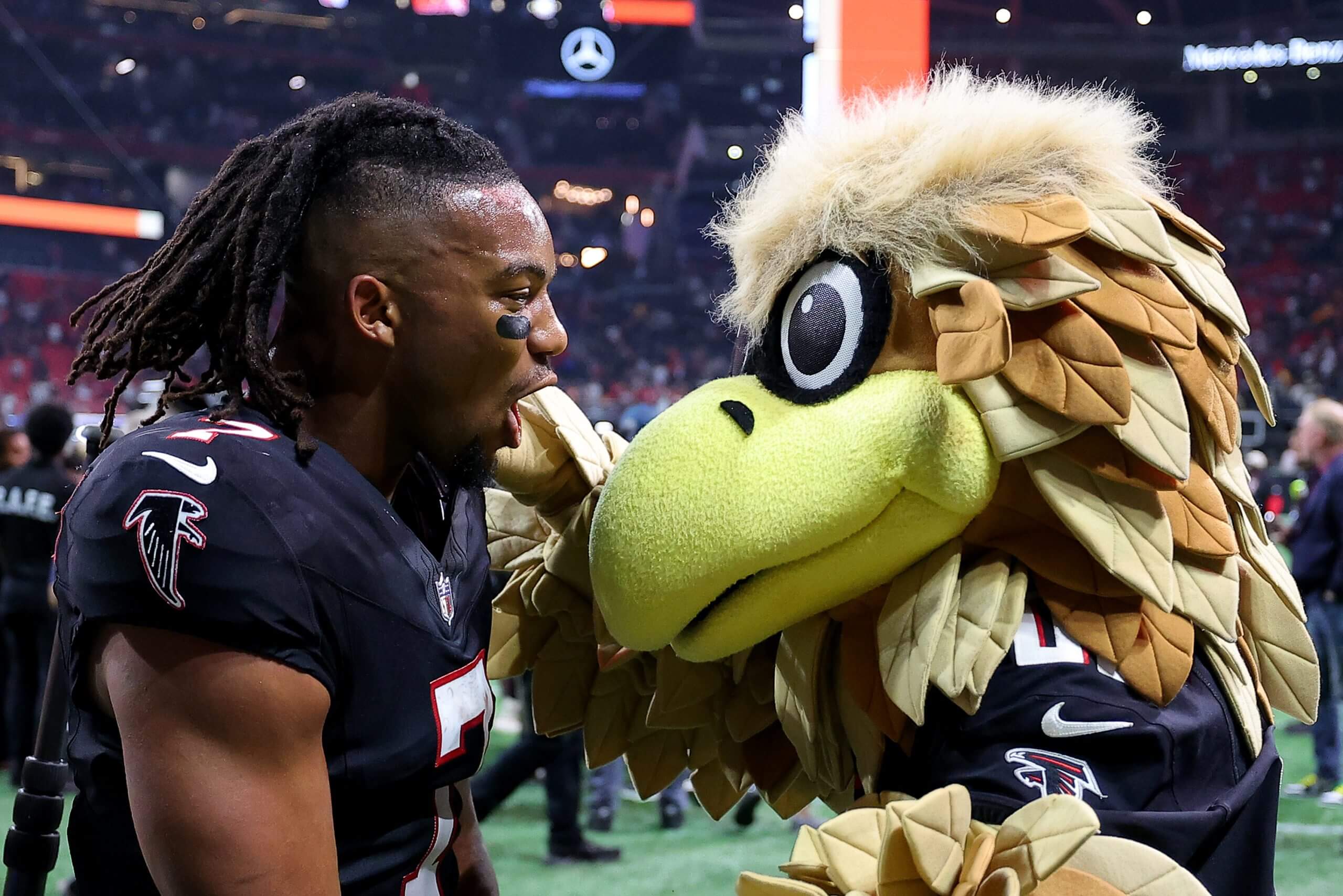 Bijan Robinson shares salutations with his favorite costumed bird. (Kevin C. Cox / Getty Images)