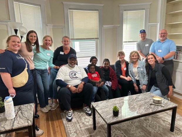 Dr. Charles Wallace II, center in white, sits with volunteers from Bain Capital, City Wide Facilities Solutions Boston, First Citizens Bank and GMA Foundations as part of Heading Home's initiative led by Danielle Ferrier, CEO, and board members Kelly Gross Douglas and Nancy Solomon.