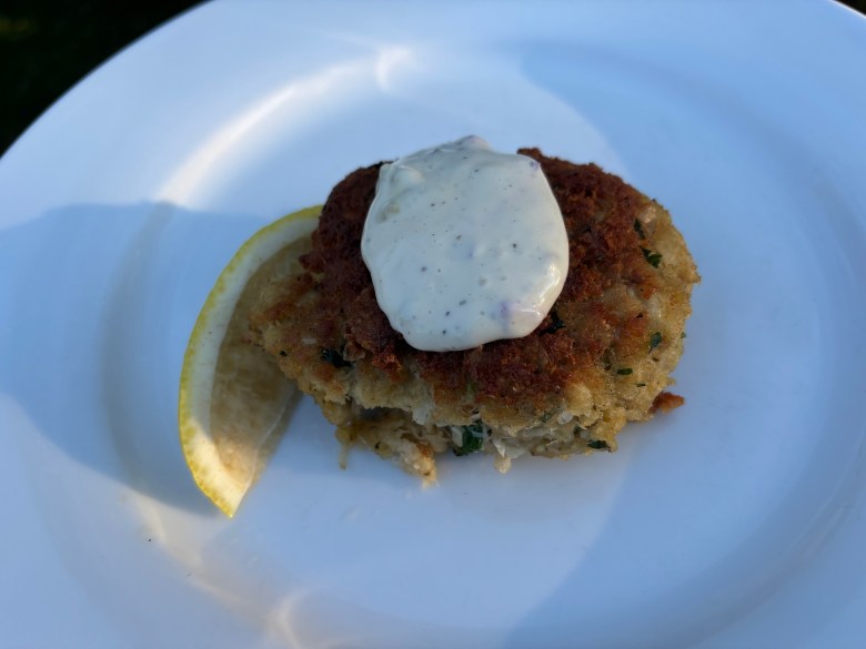 A crab cake with tartar sauce