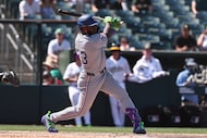 Texas Rangers' Adolis García hits an RBI single during the seventh inning of a baseball game...