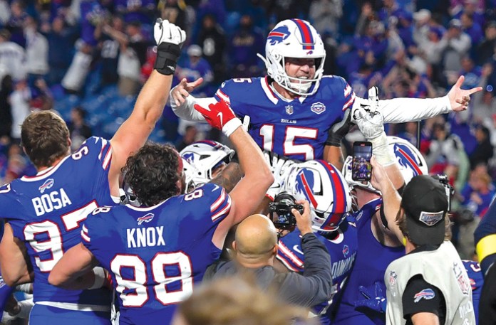 Buffalo Bills kicker Matt Prater, top, celebrates with teammates after kicking the game-winning field goal in a game against the Baltimore Ravens on Sept. 7, 2025. (Adrian Kraus/AP)