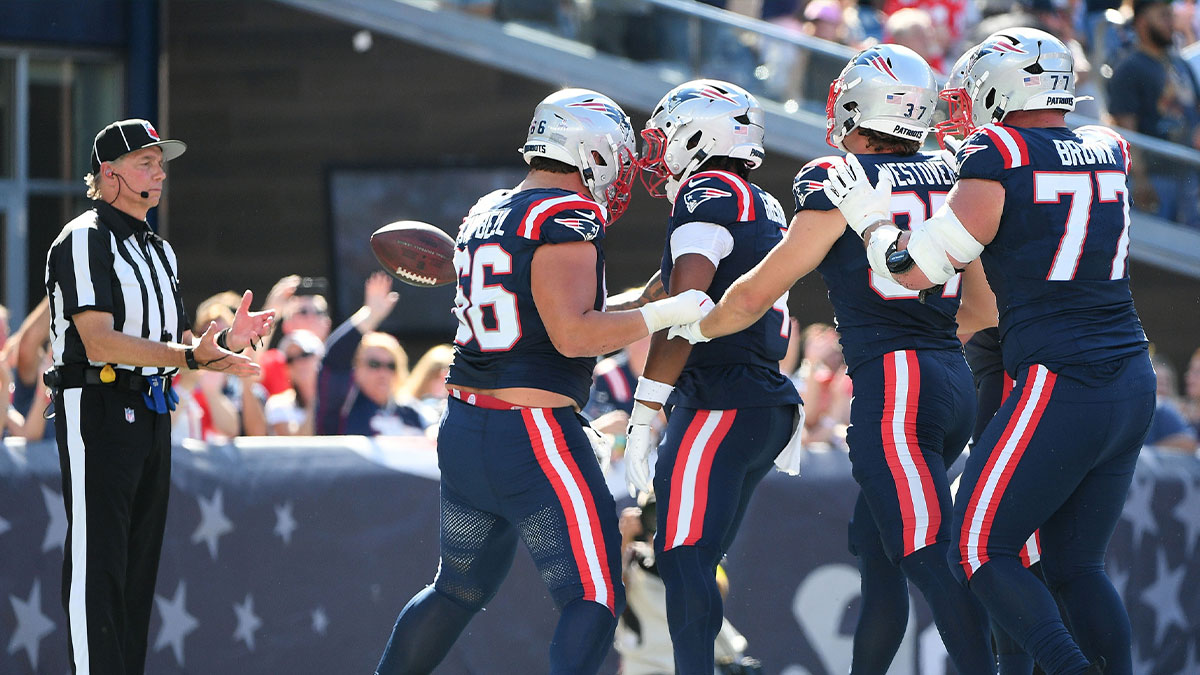  New England Patriots running back Antonio Gibson (4) tosses the ball to the official after scoring a touchdown