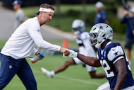Dallas Cowboys head coach Brian Schottenheimer shakes hands with defensive lineman Adedayo...