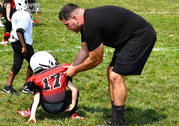 Eagles coach Mike Long lends a helping hand to Rhys Holzshu. (Photo by Rick Cawley)