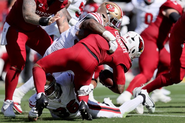 Arizona Cardinals running back James Conner (6) is tackled by San Francisco 49ers safety Marques Sigle (36) and defensive tackle Jordan Elliott (92) during an NFL football game, Sunday, Sept. 21, 2025, in Santa Clara, Calif. (AP Photo/Scot Tucker)