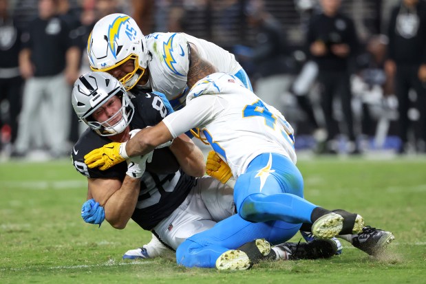 Brock Bowers #89 of the Las Vegas Raiders is tackled by Tuli Tuipulotu #45 and Troy Dye #43 of the Los Angeles Chargers during the third quarter at Allegiant Stadium on Sept. 15, 2025 in Las Vegas, Nevada. (Photo by Ian Maule/Getty Images)