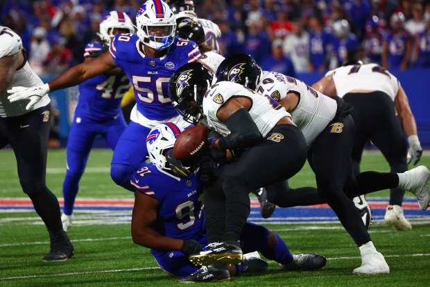 Baltimore Ravens running back Derrick Henry (22) fumble the ball as he is hit by Buffalo Bills defensive tackle Ed Oliver (91) during the second half of an NFL football game in Orchard Park, N.Y., Sunday, Sept. 7, 2025. (AP Photo/Jeffrey T. Barnes)