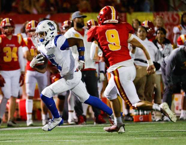 San Diego's Kye Cooper (4) runs the ball against Mt. Carmel's Isaac Castro (9) during their game at Mt. Carmel High School on Friday, Sept. 13, 2024 in San Diego, CA. (Meg McLaughlin / The San Diego Union-Tribune)