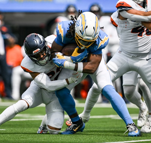 Brandon Jones (22) of the Denver Broncos wraps up Najee Harris (22) of the Los Angeles Chargers during the first quarter at SoFi Stadium in Inglewood, California on Sunday, Sept. 21, 2025. (Photo by AAron Ontiveroz/The Denver Post)