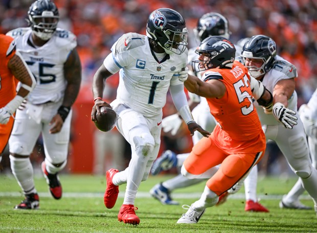 Jonah Elliss (52) of the Denver Broncos gets a hand...