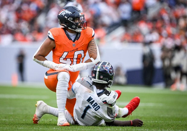 Justin Strnad (40) of the Denver Broncos kneels over Cam...