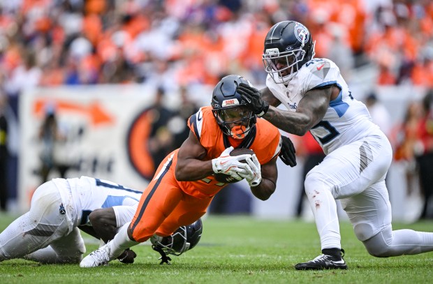 Dre'Mont Jones (45) of the Tennessee Titans stops J.K. Dobbins (27) of the Denver Broncos during the fourth quarter of the Broncos' 20-12 win at Empower Field at Mile High on Sunday, Sept. 7, 2025. (Photo by AAron Ontiveroz/The Denver Post)