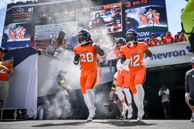 Tyler Badie (28) and RJ Harvey (12) of the Denver...