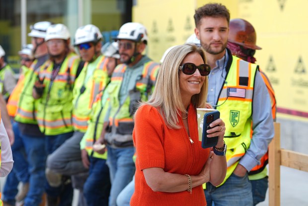 Denver Broncos co-owner Carrie Walton Penner talks to workers during a topping out ceremony for the NFL football team's new training facility, Friday, Aug. 1, 2025, in Centennial, Colo. (AP Photo/David Zalubowski)