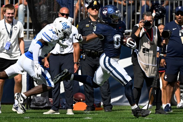UConn running back Cam Edwards (0) runs for a 73 yard touchdown while pursued by Central Connecticut defensive back Deonte Douglas (38) during an NCAA college football game at Pratt & Whitney Stadium at Rentschler Field in East Hartford, Saturday, Aug. 30, 2025. (Jessica Hill/Special to the Courant)