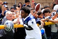 Dallas Cowboys cornerback DaRon Bland (26) slaps hands with fans as he arrives for  training...