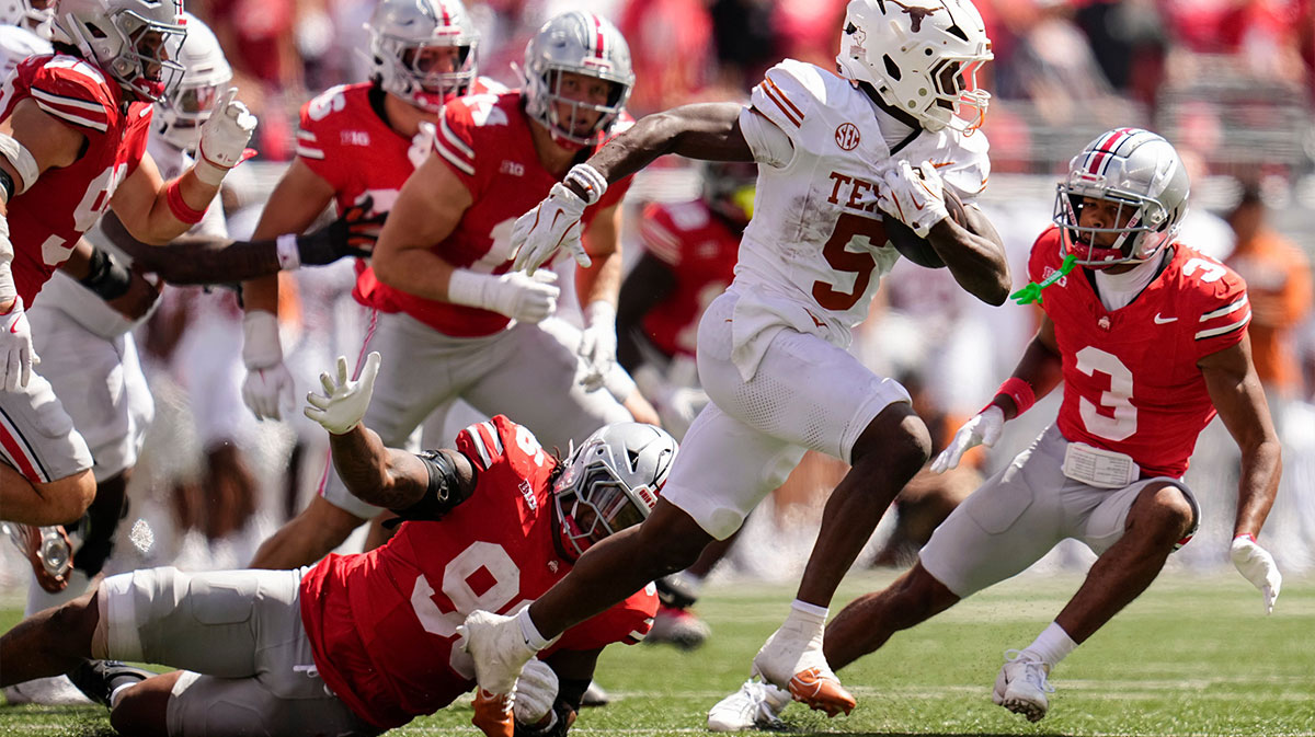 Texas Longhorns running back Quintrevion Wisner (5) runs past Ohio State Buckeyes defensive end Eddrick Houston (96) during the second half of the NCAA football game at Ohio Stadium on Aug. 30, 2025. Ohio State won 14-7.