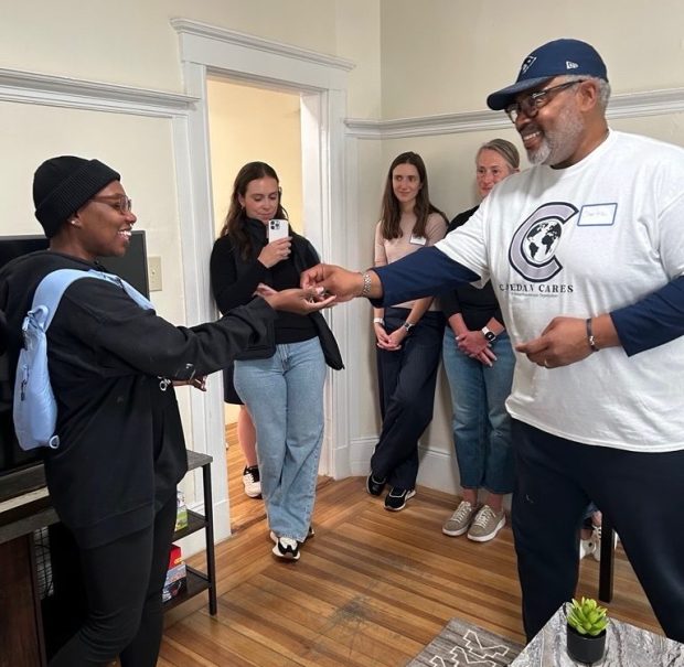 Dr. Charles Wallace II, right, hands the keys to a newly furnished apartment to a single mother as part of Heading Home's "Up and Out Move" program and acollaboration with the Caedan Cares foundation.